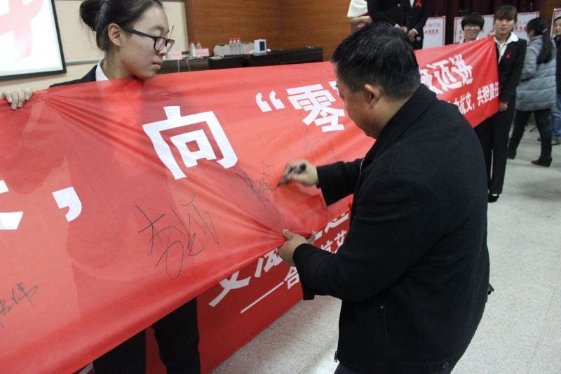 參加活動的領導在條幅上簽字